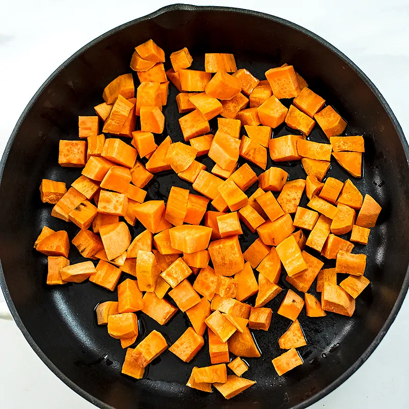 Cast iron skillet with diced sweet potatoes