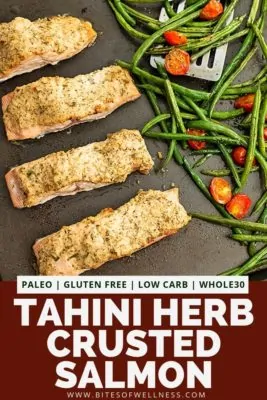Sheet pan with tahini herb crusted salmon and green beans and tomatoes.