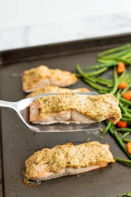 Spatula holding a tahini crusted salmon filet.