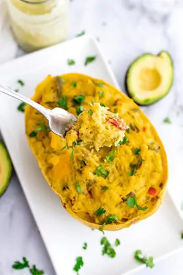 Fork holding a bite of creamy spaghetti squash bake.