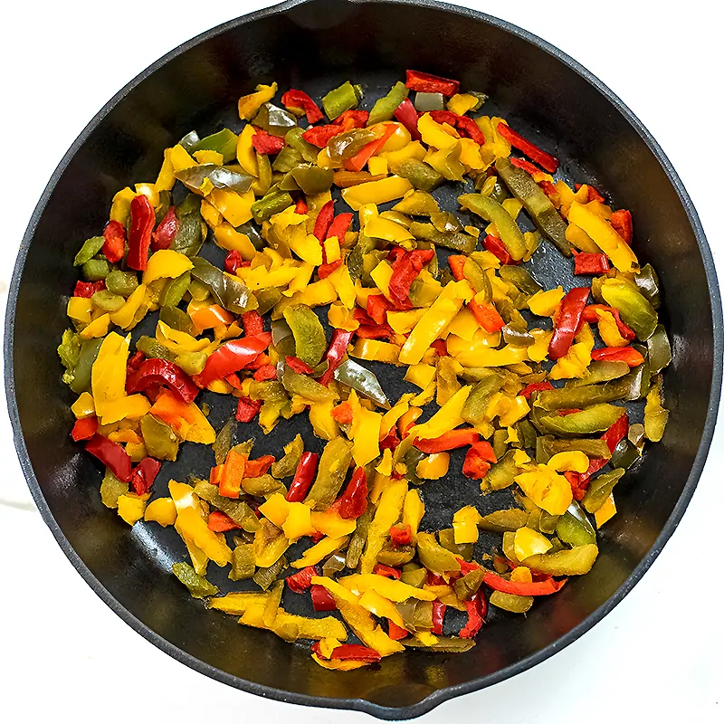 Cast iron skillet with cooked peppers.