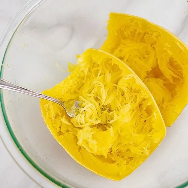 Glass bowl with cooked spaghetti squash.