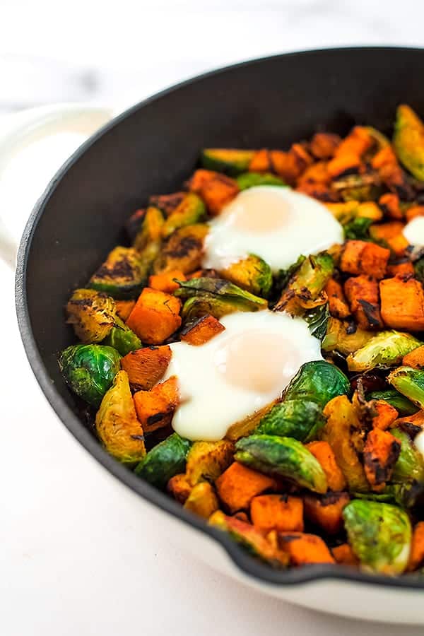 Sweet potato hash with eggs in a cast iron skillet.
