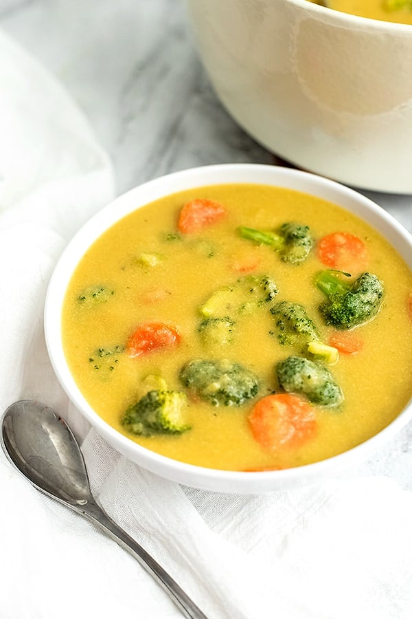 Bowl of broccoli cheese soup with a spoon to the left of the bowl.