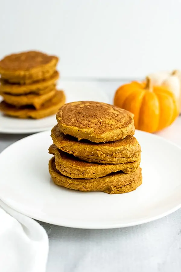 Stack of protein pumpkin pancakes on a white plate.