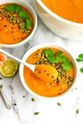 Spoonful of soup being held above the bowl of soup.