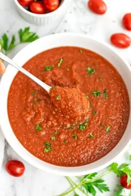 Spoon holding a serving of homemade Whole30 spaghetti sauce.