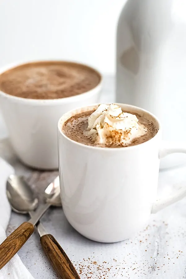 White mug filled with protein hot chocolate with whipped cream.