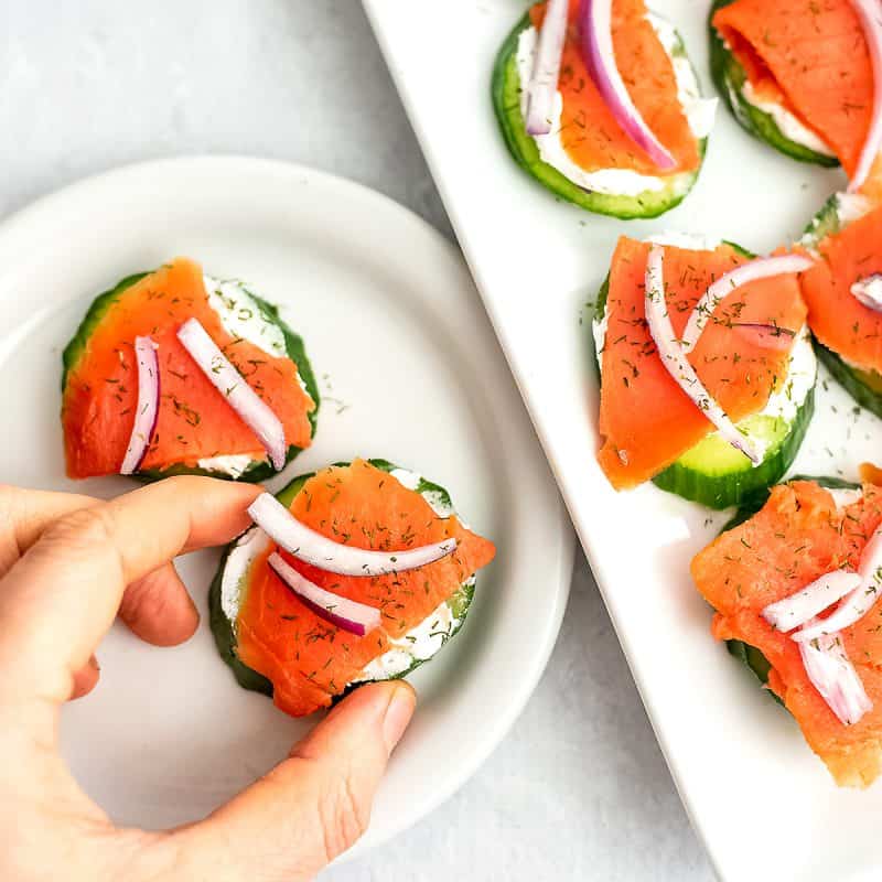Smoked salmon cucumber bite on a small white plate.
