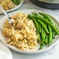 Plate filled with Chicken Thighs and Rice with green beans.