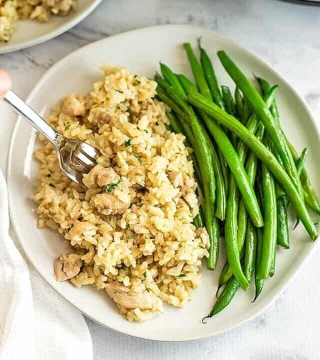 Instant Pot Brown rice and chicken thighs on a plate with green beans.