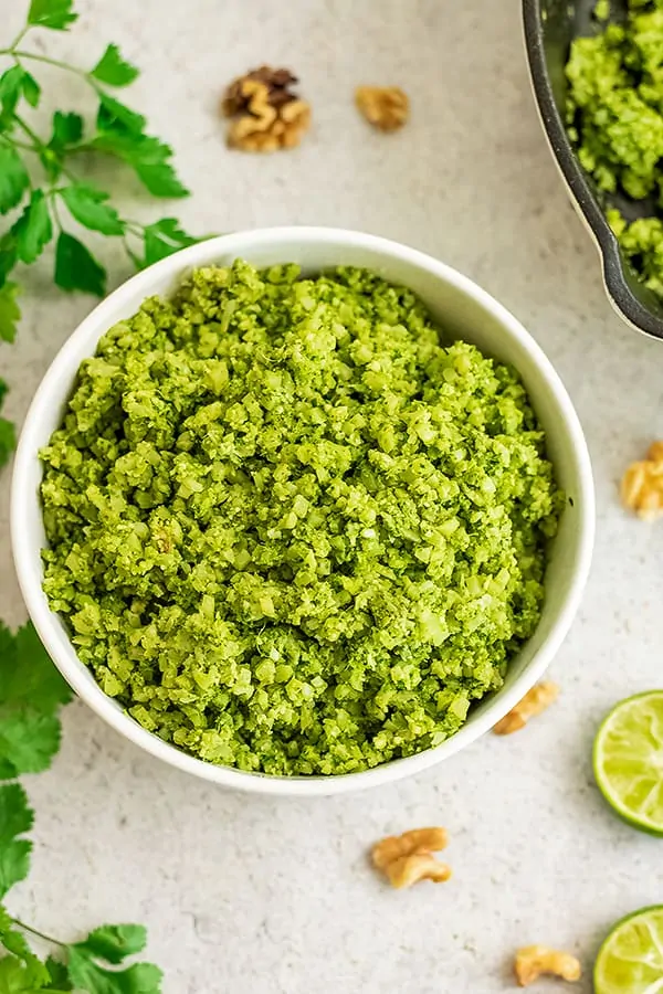 Large white bowl filled with green cauliflower rice.