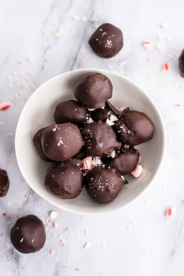 Bowl full of peppermint truffles with candy cane pieces.