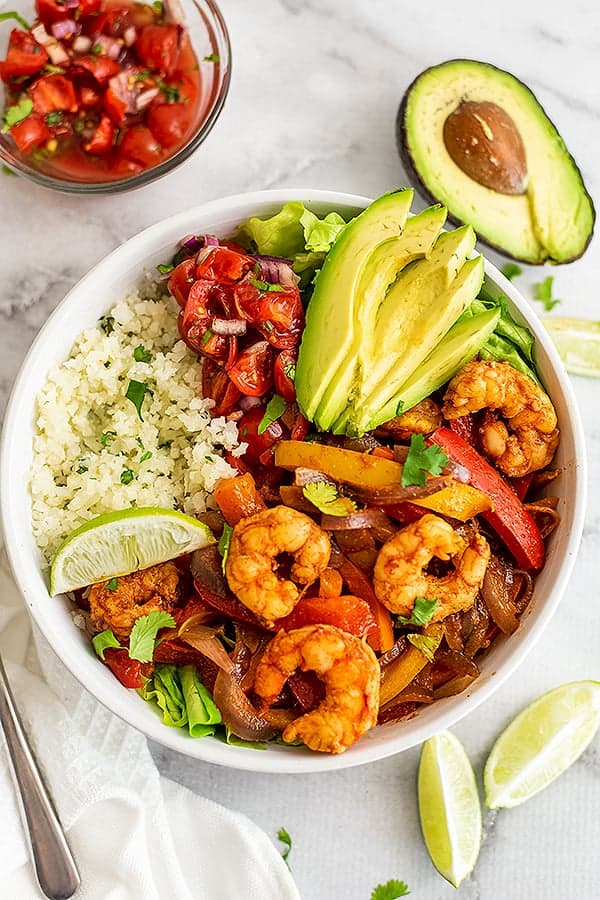 Shrimp fajita bowls filled with avocado, cauliflower rice and salsa.