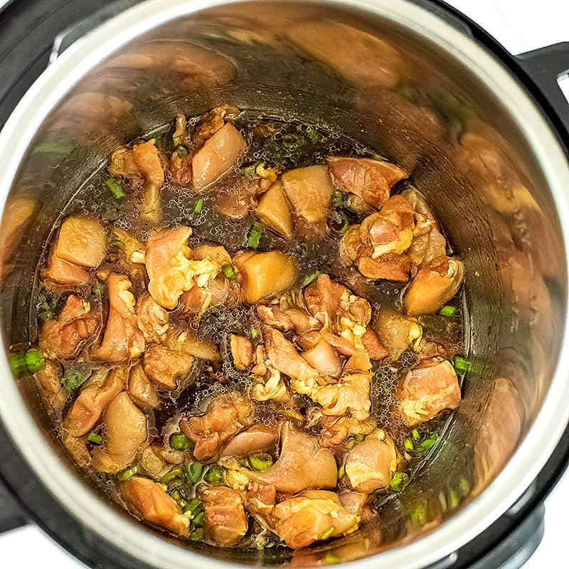 Chicken cubes stirred with sauce before adding noodles.