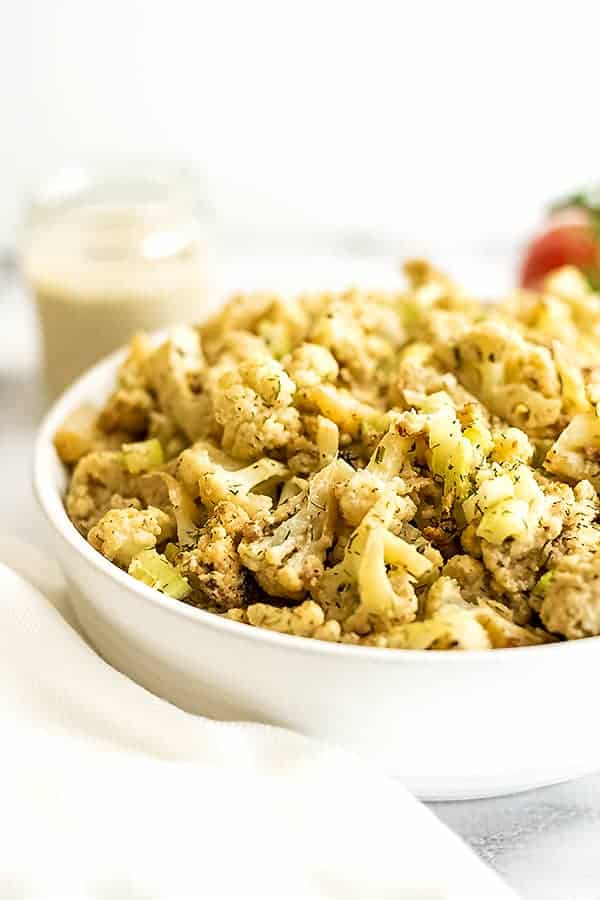 Cauliflower potato salad in a large white bowl.