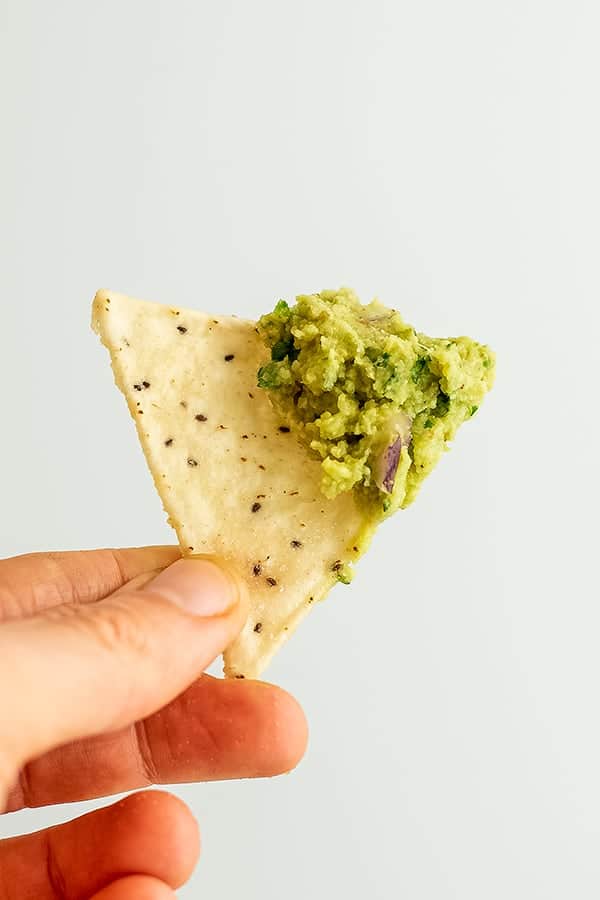 Single chip with roasted cauliflower guacamole on top.