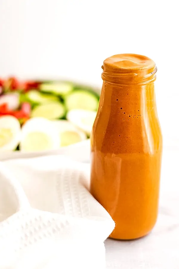Large bottle filled with homemade French dressing.