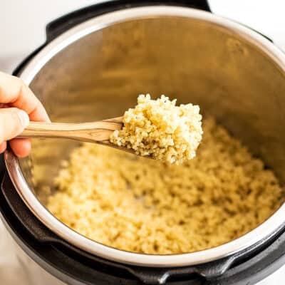 Quinoa being scooped out of the instant pot.