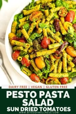 Large bowl filled with pesto pasta salad with sun dried tomatoes.