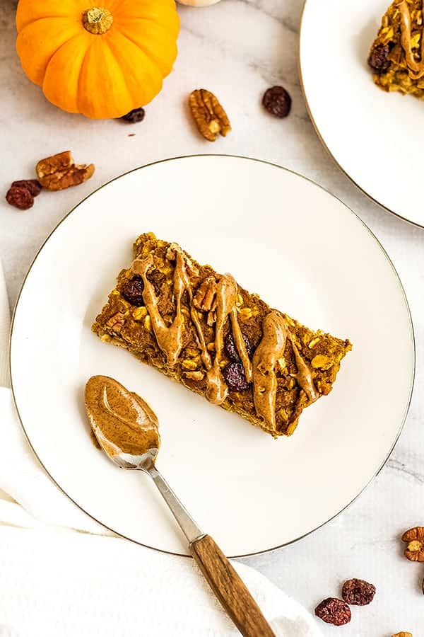 Single pumpkin oatmeal breakfast bar on white plate.