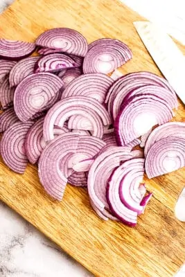 Sliced red onion on a cutting board.