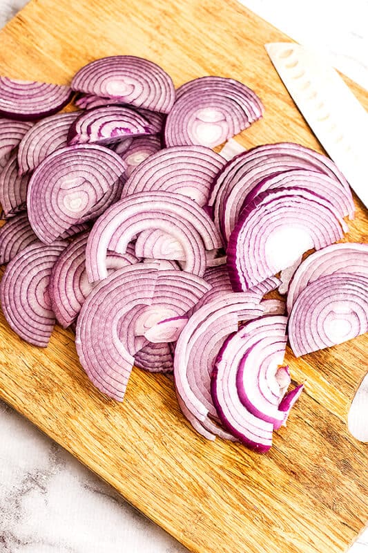 Sliced red onion on a cutting board.