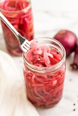 Forkful of pickled onions out of the jar.