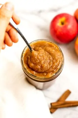 Spoon in a jar of paleo apple butter.