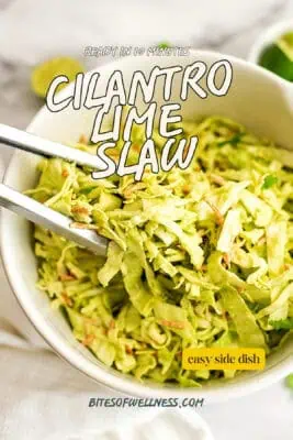 Tongs lifting cilantro lime slaw from a bowl.