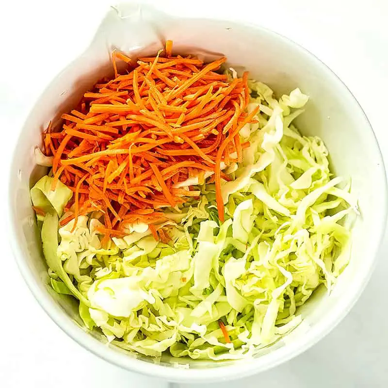 Shredded cabbage and carrots in a bowl.