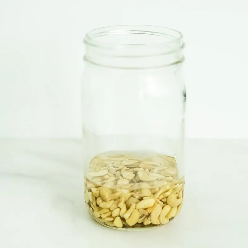 Cashews soaking in a glass jar.