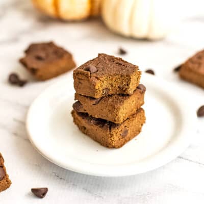 Pumpkin brownie with a bite removed on a plate.