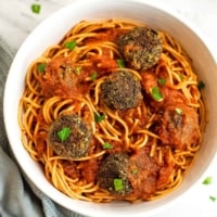 Spaghetti and quinoa lentil meatballs in a white bowl.