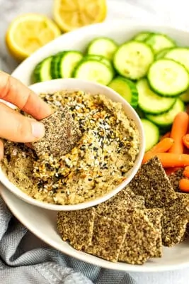Cracker being dipped in everything bagel dip.