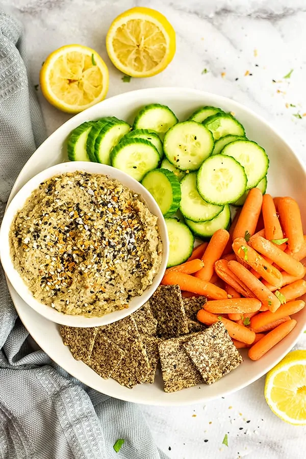 Everything bagel hummus on a tray with other veggies.