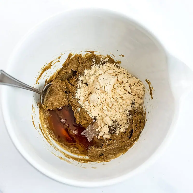 Dry ingredients being added to the protein peanut butter cookie dough mix.
