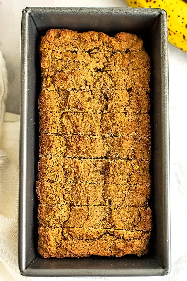 Vegan protein banana bread in a loaf tin, sliced.