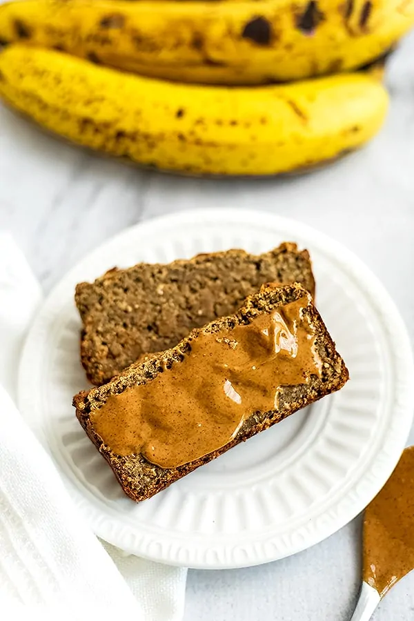 2 slices of banana bread, one has almond butter on top.