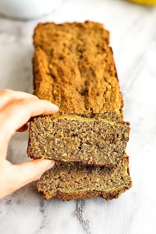 Protein banana bread cut into slices on a white serving platter.