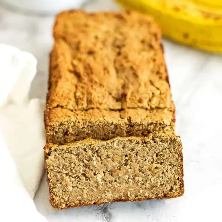 One slice of protein banana bread in front of the loaf.