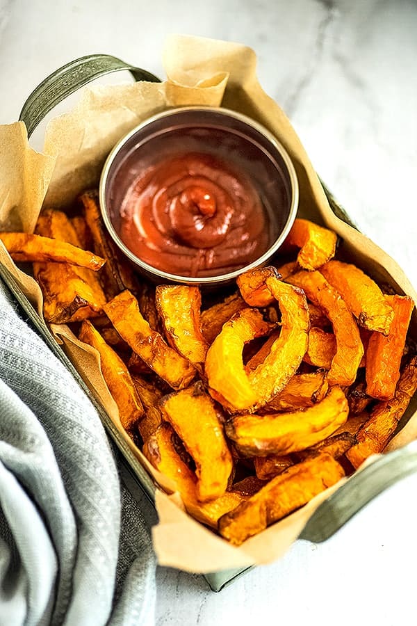 Basket of air fryer butternut squash fries and ketchup.