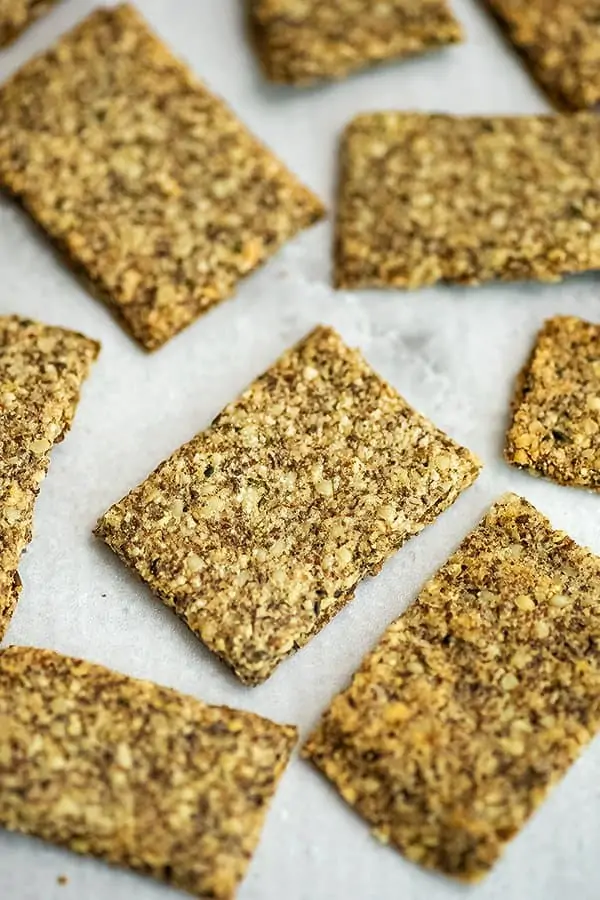 Handful of hemp almond flax crackers on a plate. 