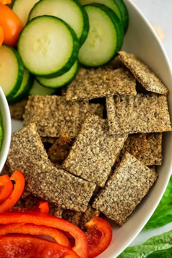 Almond flax crackers in a bowl with veggies.