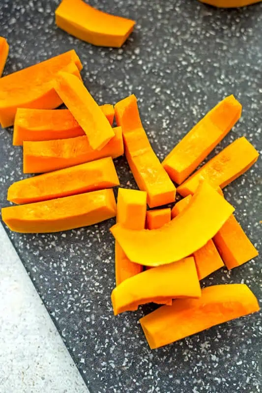 Butternut squash cut into 1 inch long pieces before cubing.