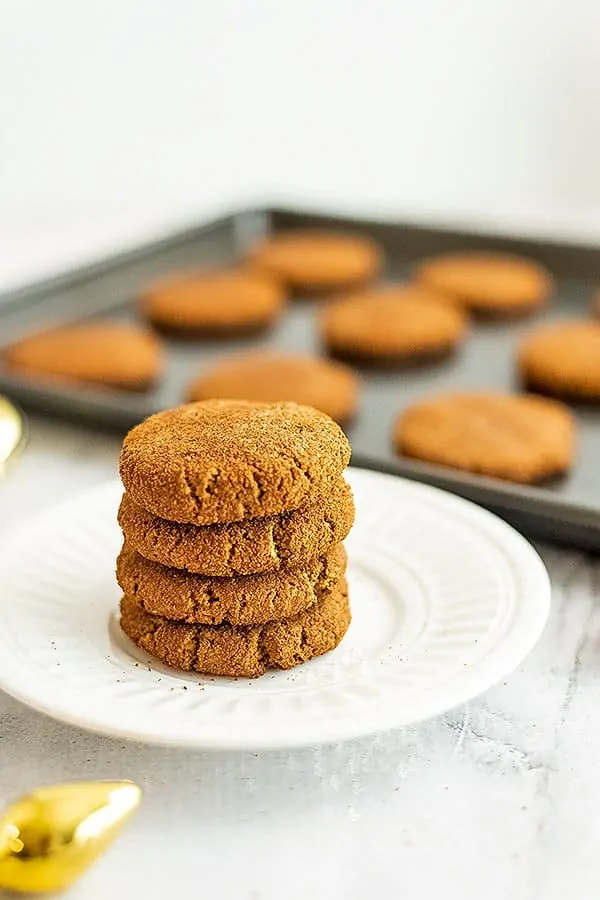 Paleo molasses cookies on a plate stacked 4 high.