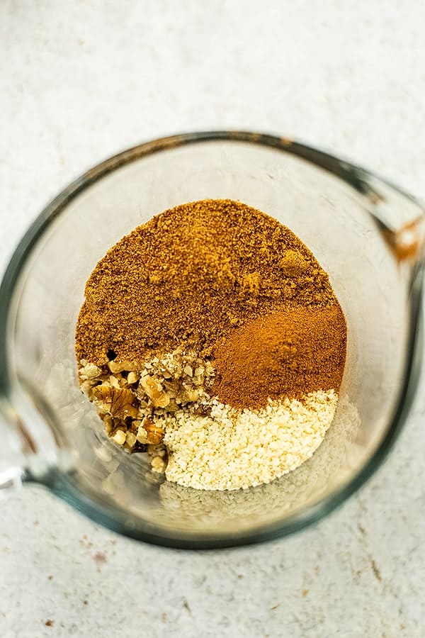 Ingredients for pecan topping in a glass measuring cup.