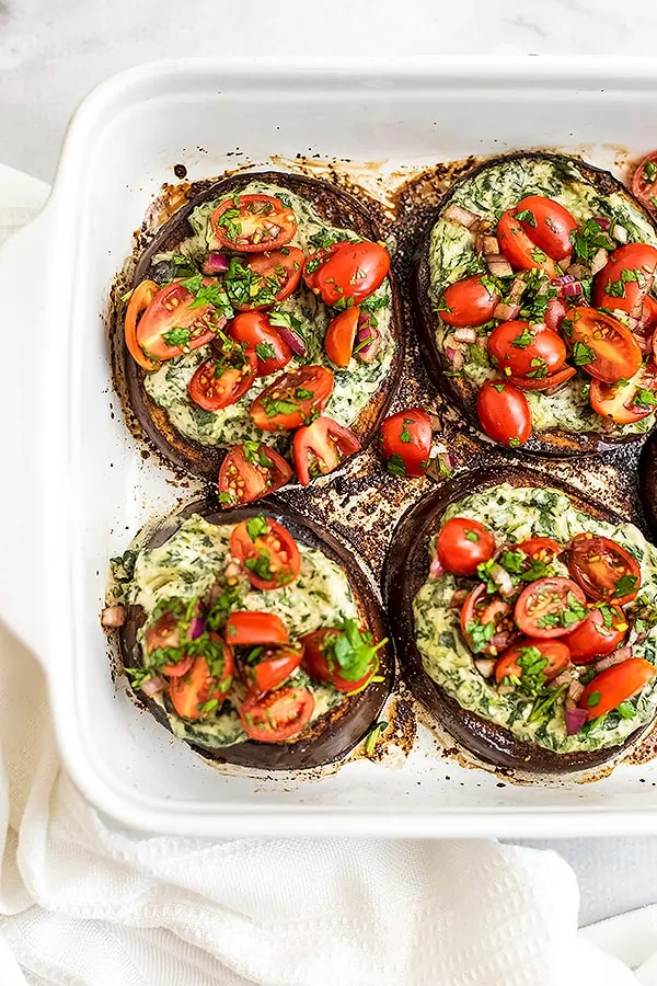 Four balsamic eggplant in a white baking dish.
