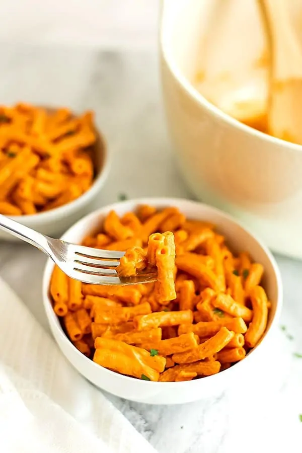 Fork holding creamy roasted red pepper pasta.