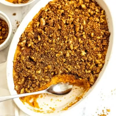 Spoon in a casserole dish filled with sweet potato casserole.